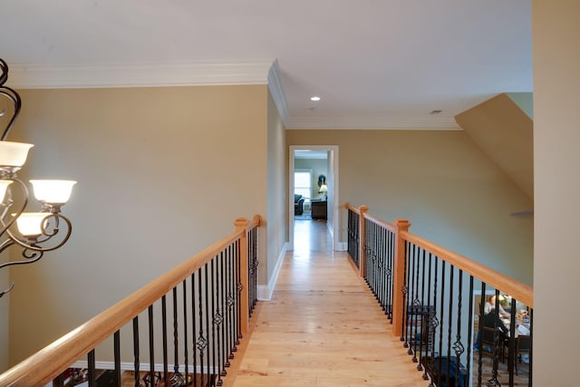 hallway with light wood-type flooring and ornamental molding