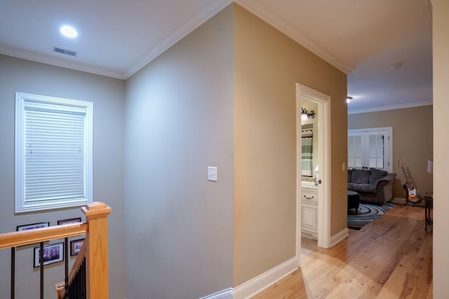 corridor featuring crown molding and light hardwood / wood-style floors