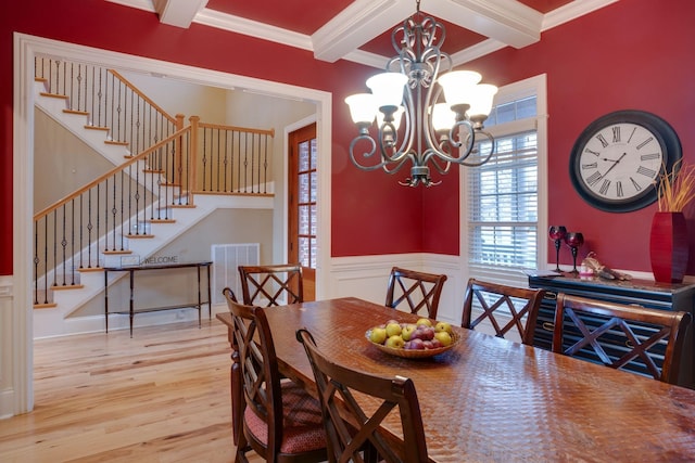 dining area featuring light hardwood / wood-style floors, a chandelier, ornamental molding, and beamed ceiling