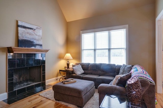 living room with lofted ceiling, a fireplace, and hardwood / wood-style flooring