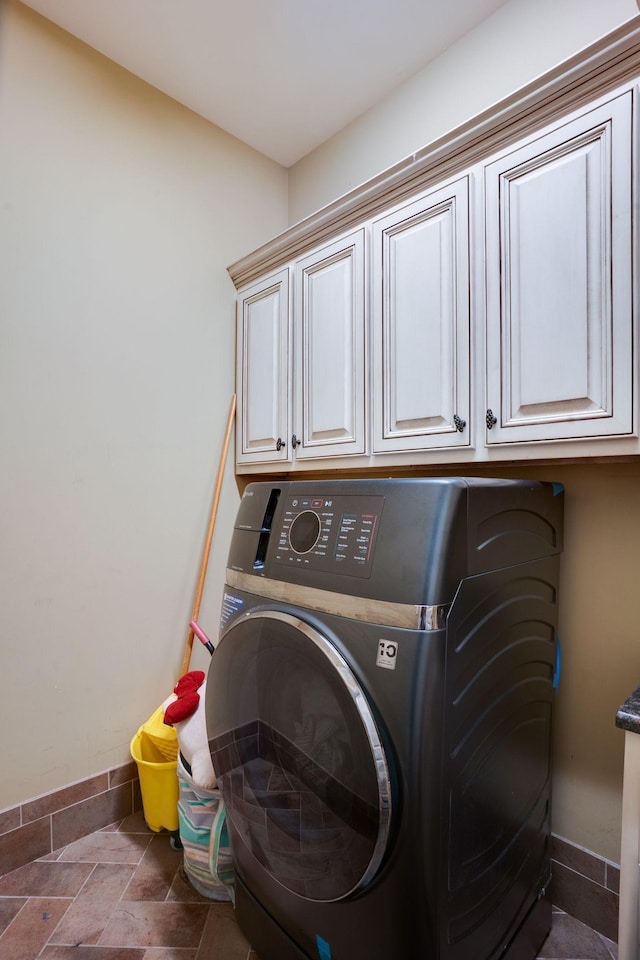 laundry room featuring washer / dryer and cabinets