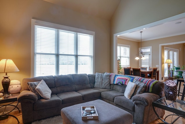 living room with vaulted ceiling, ornamental molding, a chandelier, and hardwood / wood-style floors