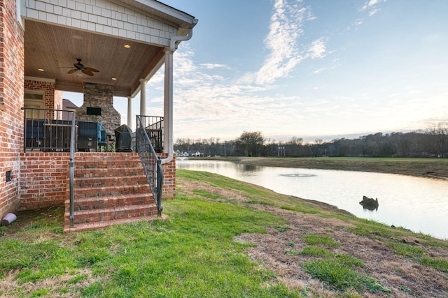 view of yard with a water view and ceiling fan