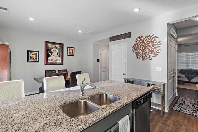 kitchen featuring sink, stainless steel dishwasher, dark hardwood / wood-style floors, and light stone countertops