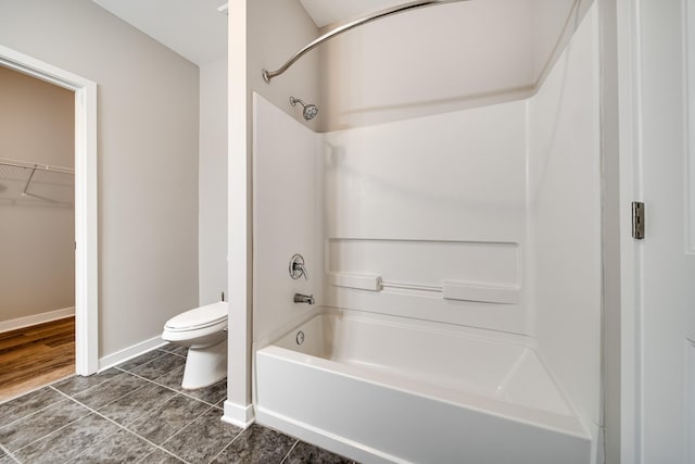 bathroom featuring tub / shower combination, toilet, and tile patterned flooring