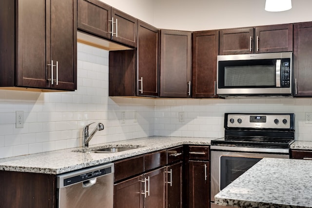 kitchen with sink, backsplash, appliances with stainless steel finishes, and dark brown cabinetry