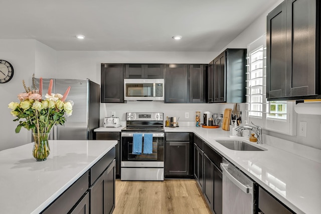 kitchen featuring light wood-type flooring, appliances with stainless steel finishes, and sink