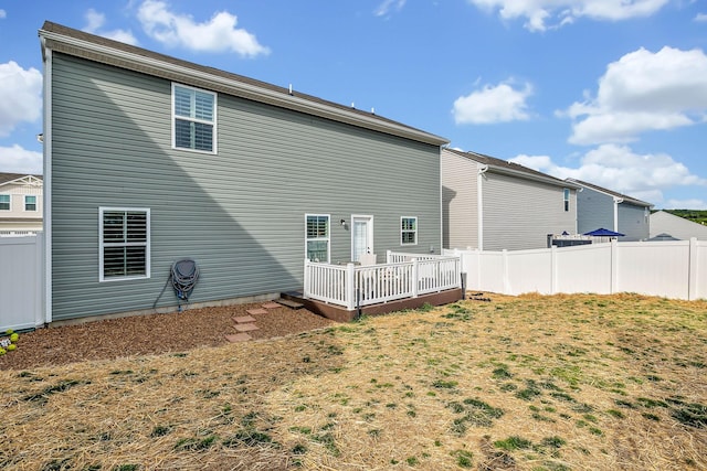 rear view of house with a lawn and a deck