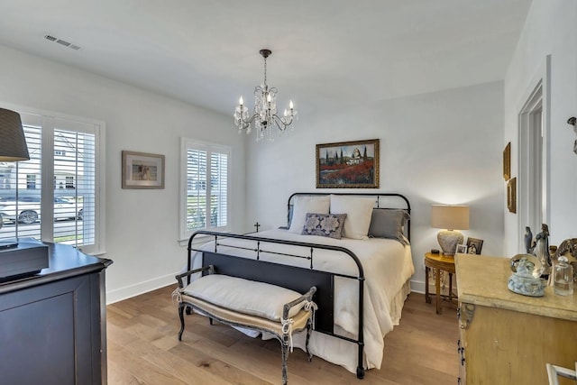 bedroom featuring a notable chandelier and light hardwood / wood-style floors