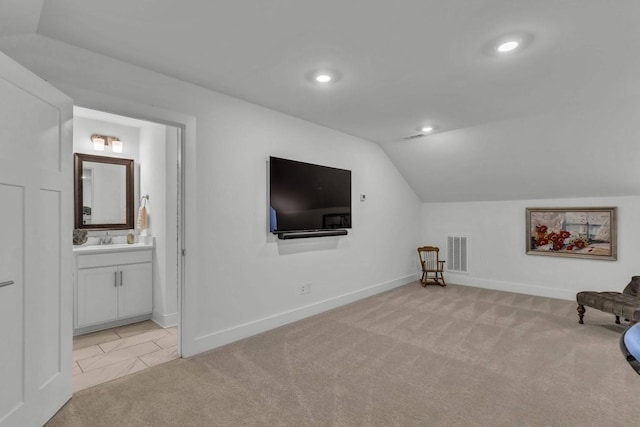 unfurnished room featuring light carpet, lofted ceiling, and sink