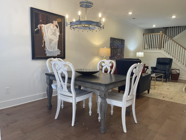 dining space featuring dark wood-type flooring, ornamental molding, and an inviting chandelier