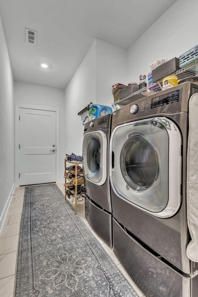 clothes washing area with tile patterned floors and washer and clothes dryer