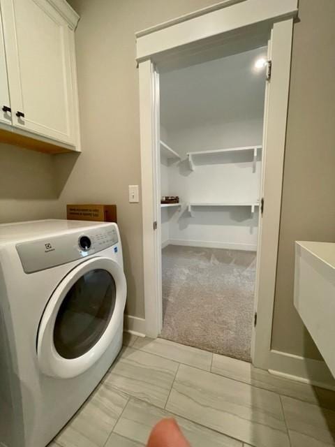 washroom featuring cabinets, washer / dryer, and light carpet