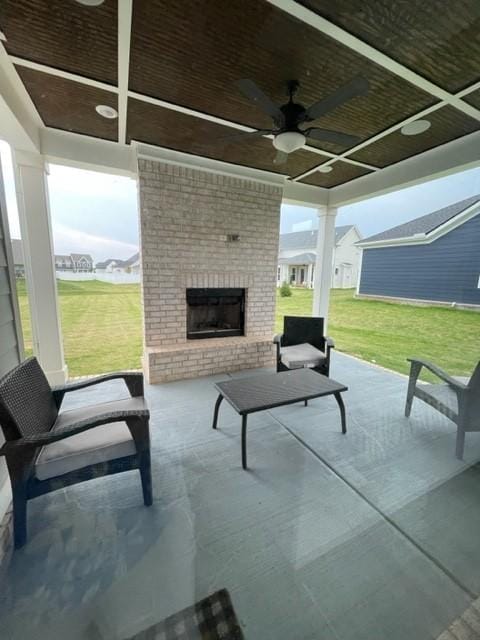 view of patio / terrace with ceiling fan and an outdoor brick fireplace