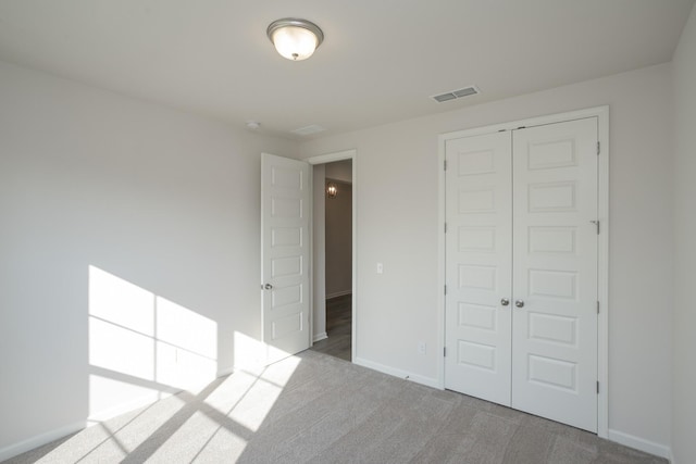 unfurnished bedroom featuring light carpet and a closet