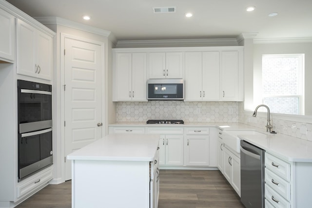 kitchen with sink, white cabinetry, appliances with stainless steel finishes, and a center island