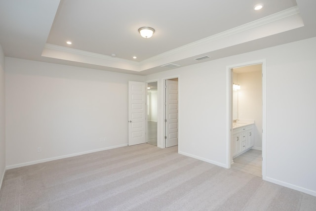 unfurnished bedroom with light colored carpet, connected bathroom, crown molding, and a raised ceiling