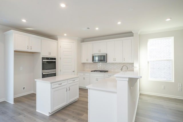 kitchen with white cabinets, appliances with stainless steel finishes, and a center island