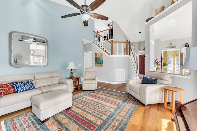 living room featuring a high ceiling, ceiling fan, and hardwood / wood-style flooring