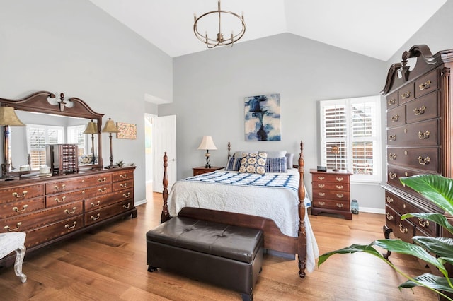 bedroom with multiple windows, hardwood / wood-style floors, and vaulted ceiling