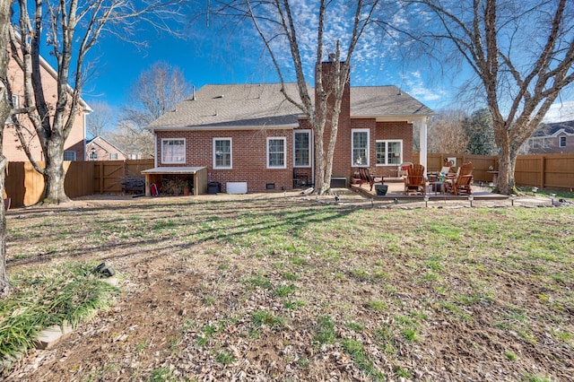 rear view of property featuring a lawn and a patio area