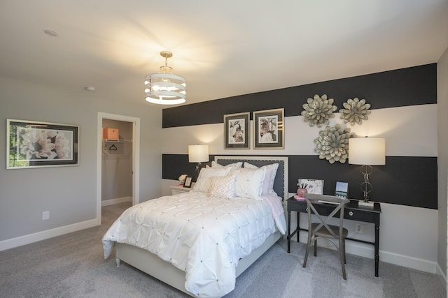 carpeted bedroom with a closet, a walk in closet, and an inviting chandelier