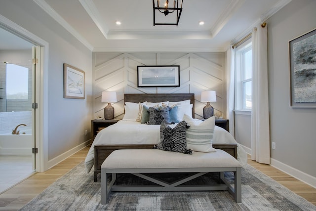 bedroom featuring ornamental molding, light hardwood / wood-style floors, and a tray ceiling