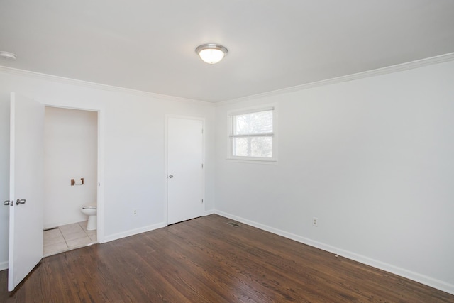 spare room featuring wood-type flooring and crown molding