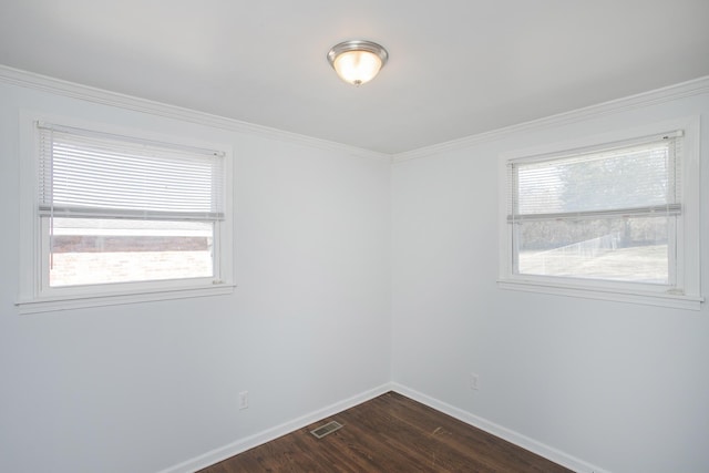 empty room featuring crown molding, plenty of natural light, and dark hardwood / wood-style floors