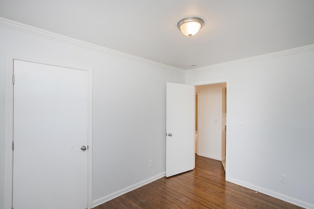 unfurnished bedroom featuring crown molding and dark hardwood / wood-style flooring