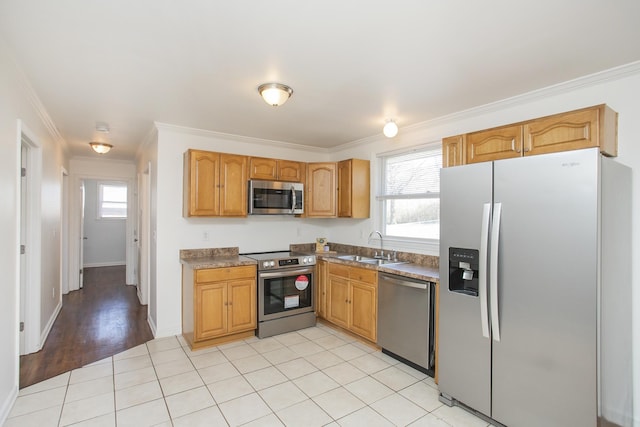 kitchen featuring sink, ornamental molding, stainless steel appliances, and light tile patterned flooring