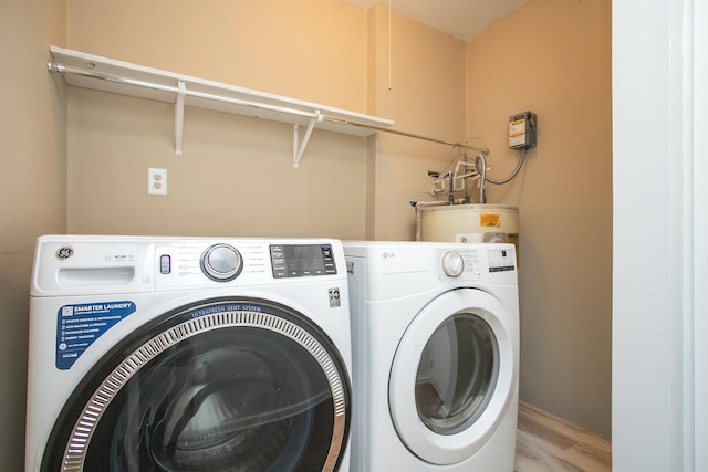 clothes washing area with water heater and washer and dryer