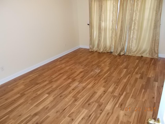 unfurnished room with hardwood / wood-style flooring