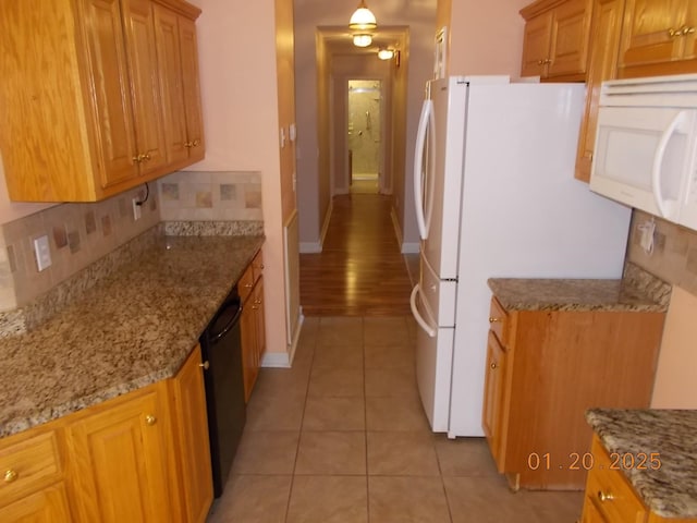 kitchen with light stone counters, light tile patterned flooring, white appliances, and tasteful backsplash