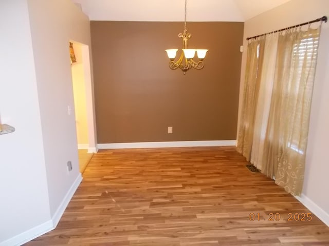 unfurnished dining area featuring a chandelier and hardwood / wood-style floors