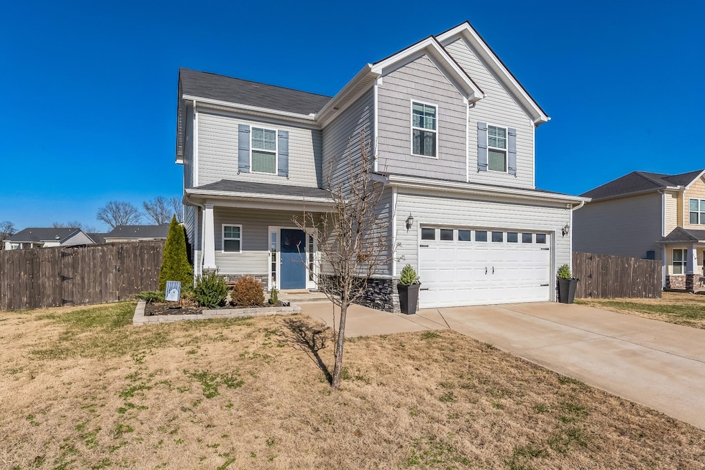 view of property featuring a garage and a front yard