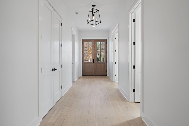 hall featuring light hardwood / wood-style floors and french doors