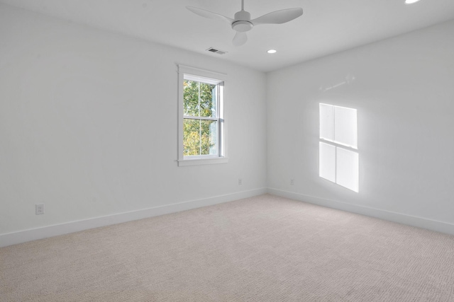 carpeted spare room featuring ceiling fan