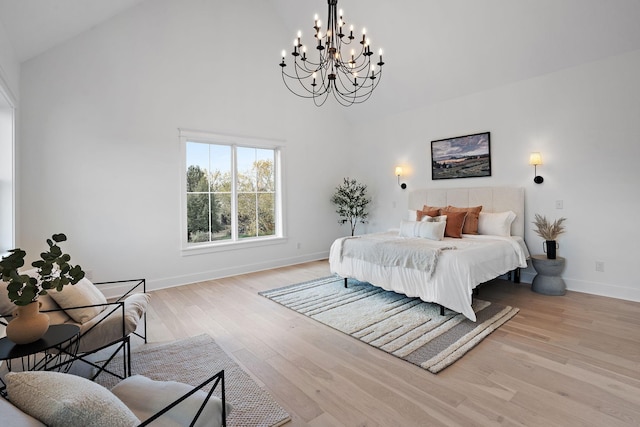 bedroom with lofted ceiling, light hardwood / wood-style flooring, and a notable chandelier