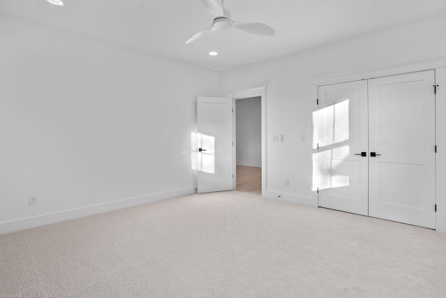 unfurnished bedroom featuring ceiling fan, light carpet, and a closet