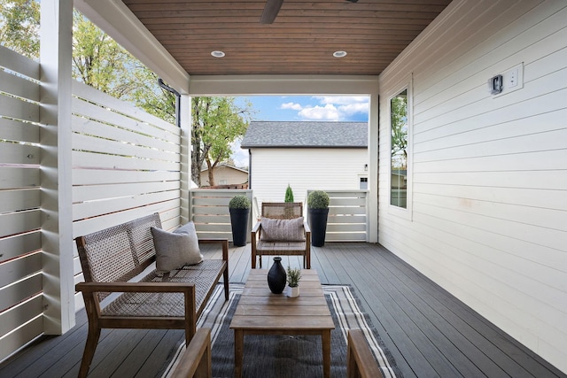 wooden terrace featuring ceiling fan and an outdoor living space