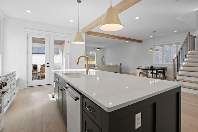 kitchen with a kitchen island with sink, hanging light fixtures, sink, and beamed ceiling