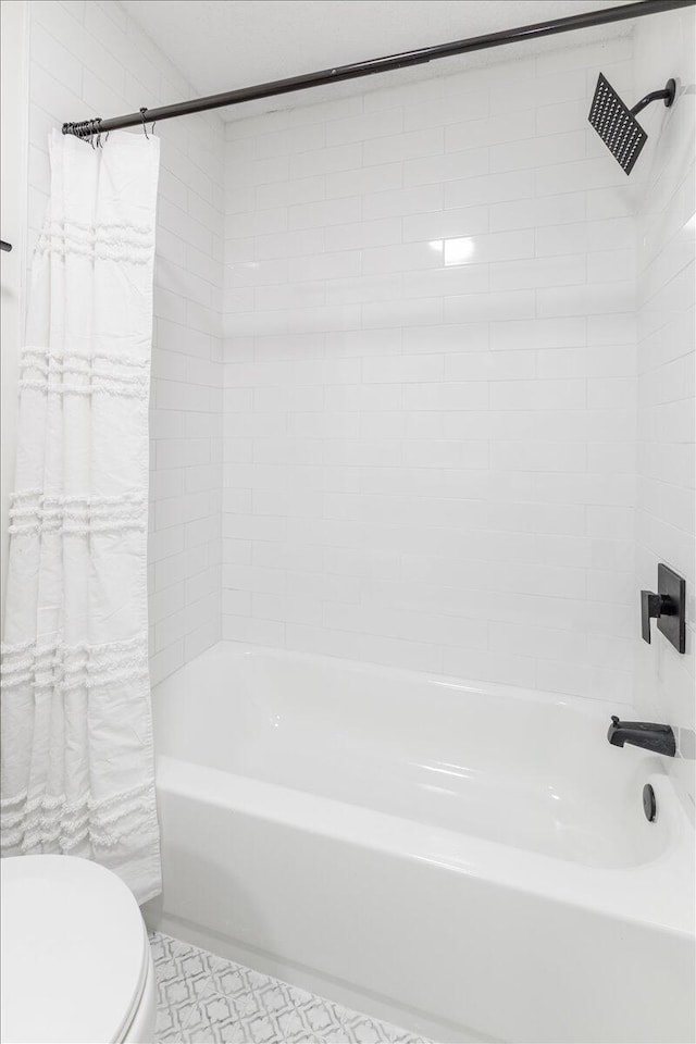 bathroom featuring toilet and shower / bath combo