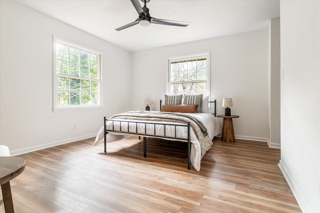 bedroom featuring hardwood / wood-style flooring, ceiling fan, and a textured ceiling