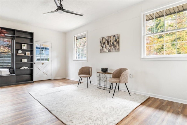 sitting room with wood-type flooring and ceiling fan