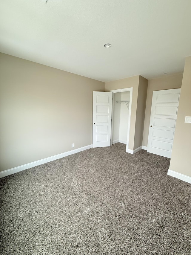 unfurnished bedroom featuring carpet flooring and a closet