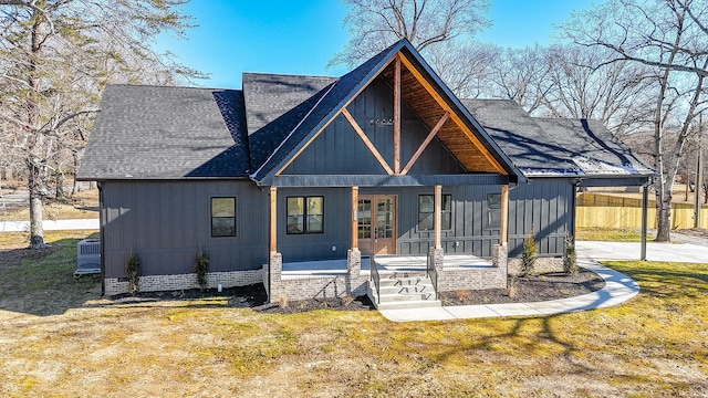 back of house with a lawn, central AC unit, and covered porch