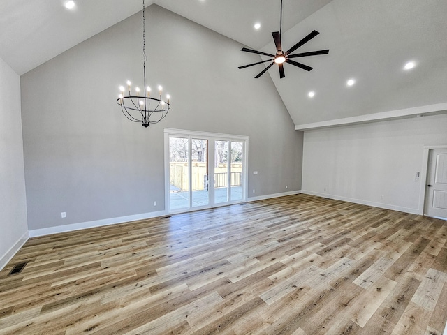 unfurnished living room featuring high vaulted ceiling, ceiling fan with notable chandelier, and light wood-type flooring