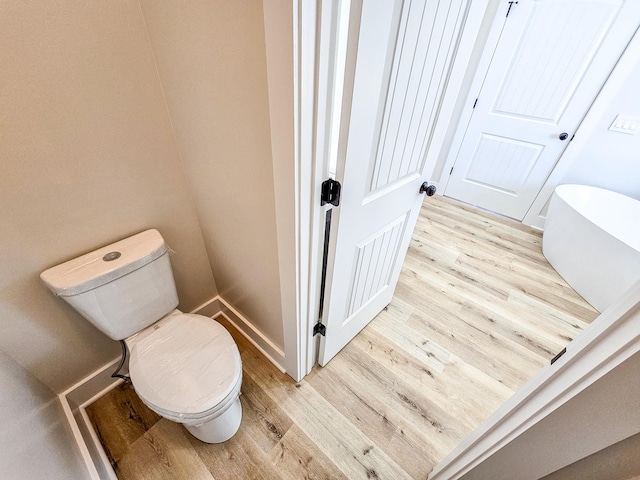 bathroom with toilet and wood-type flooring