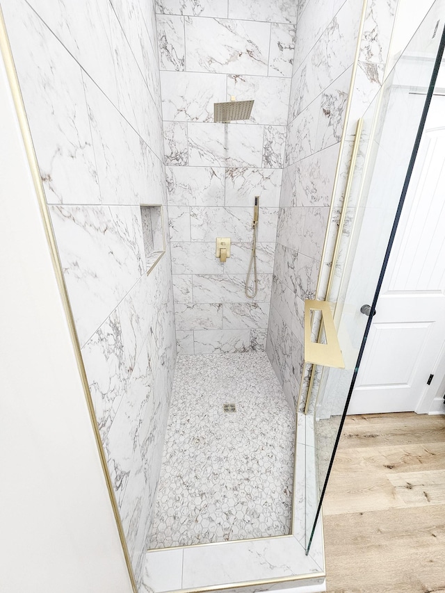 bathroom featuring a tile shower and hardwood / wood-style flooring